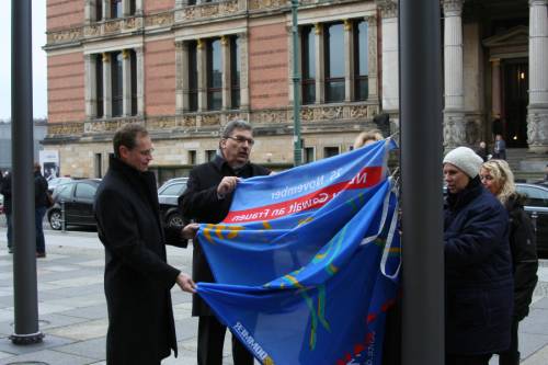 Präsident Wieland und Bürgermeiser Müller beim Hissen einer blauen Flagge, im Hintergrund der  Martin-Gropius-Bau