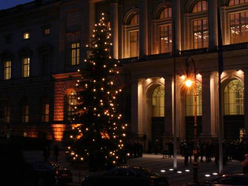 Der beleuchtete Weihnachtsbaum im Dunkeln vor dem erleuchteten Abgeordnetenhaus.