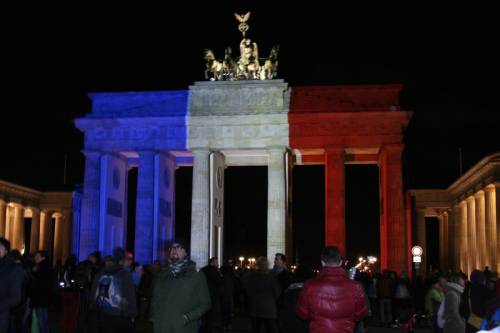 Das Brandenburger Tor bei Nacht wird mit der Flagge von Frankreich angestrahlt: Blau, Weiß Rot.