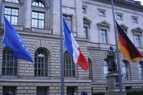 Die Fahnen vor dem Abgeordnetenhaus sind auf Halbmast gehisst. Man sieht die Flaggen von Europa, Frankreich und Deutschland.