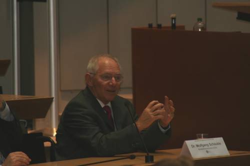 Dr. Wolfgang Schäuble gestikuliert während einer Sitzung und spricht in ein Mikrofon.