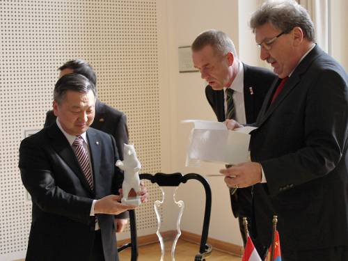 Ralf Wieland übergibt einem asiatischen Politiker eine kleine Statue des Berliner Bären. Zwei weitere Männer sind dabei.