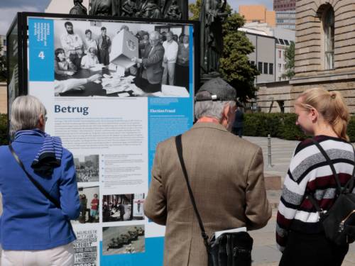 Besucher schauen sich eine Ausstellung auf dem Vorplatz des Abgeordnetenhauses von Berlin an.