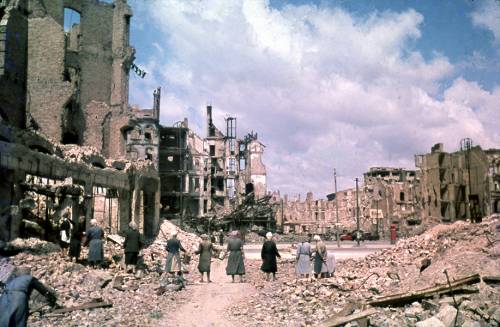 Alte Aufnahme von Berlin nach dem Krieg. Die Häuser sind zerbombt und einige Frauen bilden eine Kette, um Trümmer zu entfernen.