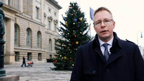 Das Bild zeigt den Präsidenten des Berliner Abgeordnetenhauses Dennis Buchner vor dem Weihnachtsbaum auf dem Vorplatz des Hauses
