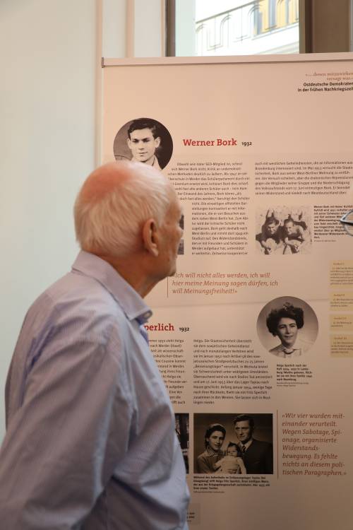 Werner Bork betrachtet ein Roll‑up der Ausstellung, auf dem seine eigene Geschichte dargestellt wird.
