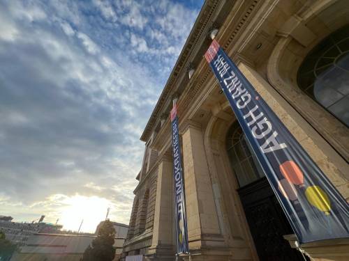 Die Front des Abgeordnetenhauses mit Bannern an der Fassade mit der Aufschrift: AGH ganz nah. Demokratiefest. Im linken oberen Teil des Bildes sieht man einen wolkigen blauen Himmel.