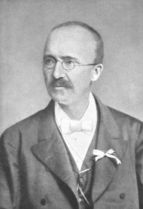 Zu erkennen ist ein schwarz weiß Porträt von Schliemann. Er is tein älterer Herr mit kurzen Haaren, Schnurrbart und runder Brille.